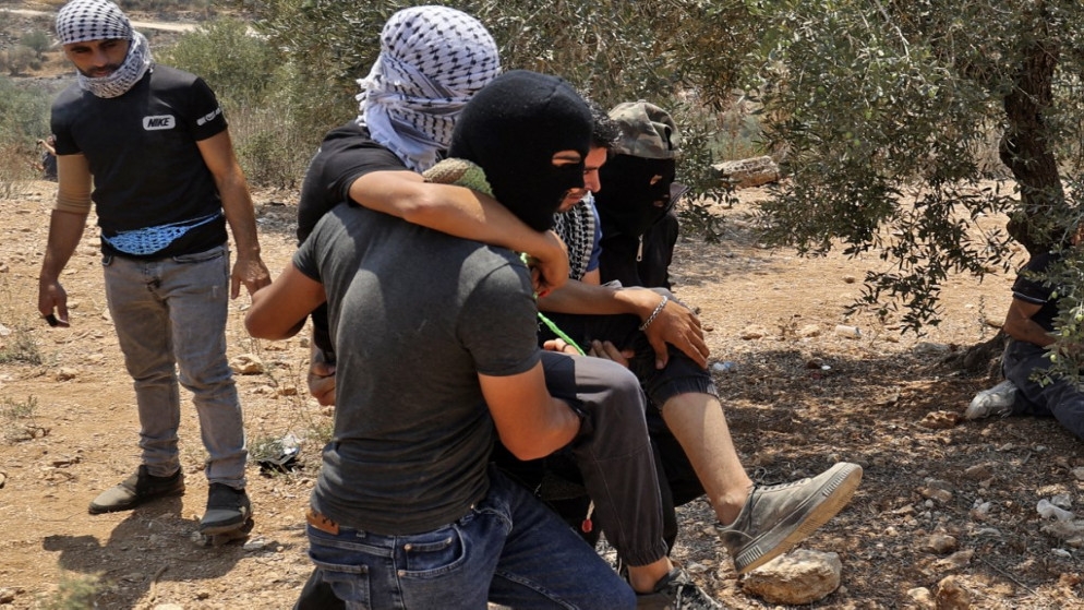 فلسطينيون ينقلون مصاب خلال مواجهات مع قوات الاحتلال الإسرائيلي في قرية بيتا شمال الضفة الغربية المحتلة، 30 تموز/يوليو 2021. (أ ف ب)