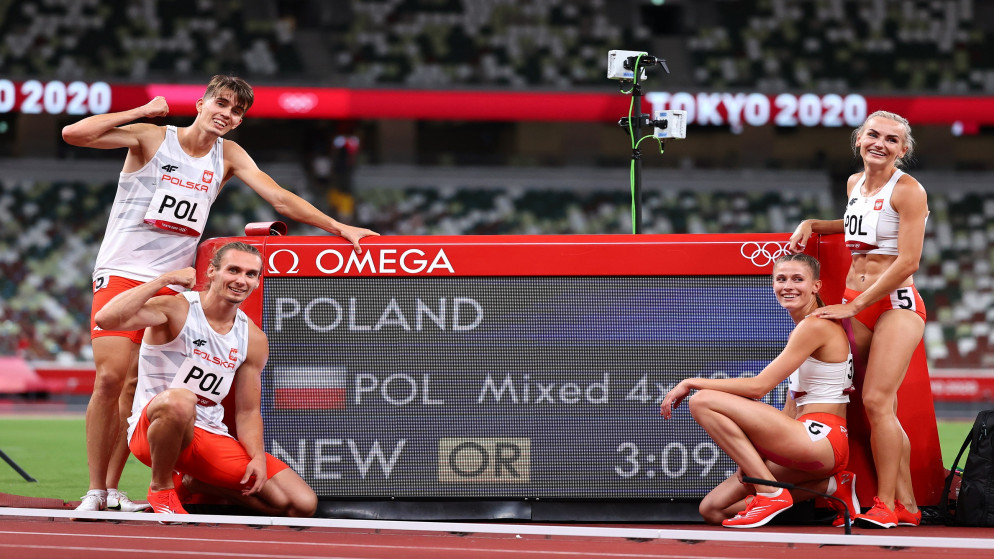 المتسابقان البولنديان في سباق التتابع المختلط 4 في 400 متر بجانب رقمهم الأولمبي. (رويترز)