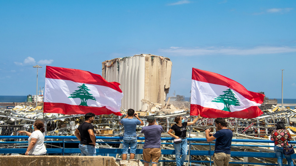 لبنانيون يلوحون بالعلم الوطني في موقع انفجار مرفأ بيروت. 08/09/2020. (shutterstock)