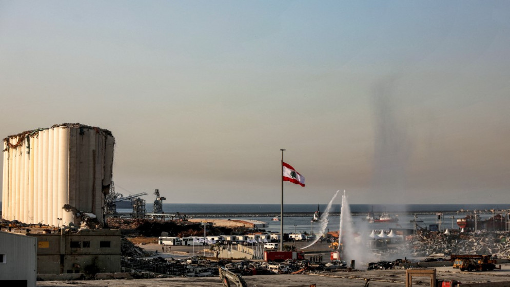 رجال إطفاء لبنانيون يطلقون المياه بالقرب من صوامع حبوب متضررة جراء الانفجار الذي وقع في مرفأ بيروت. (أ ف ب)