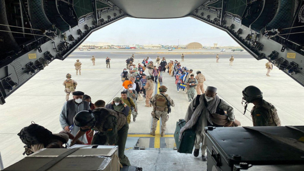 إسبان وأفغان وعائلاتهم يصطفون أمام طائرة إيرباص تابعة للقوات الجوية الإسبانية في مطار كابل متجهة إلى دبي. (أ ف ب)
