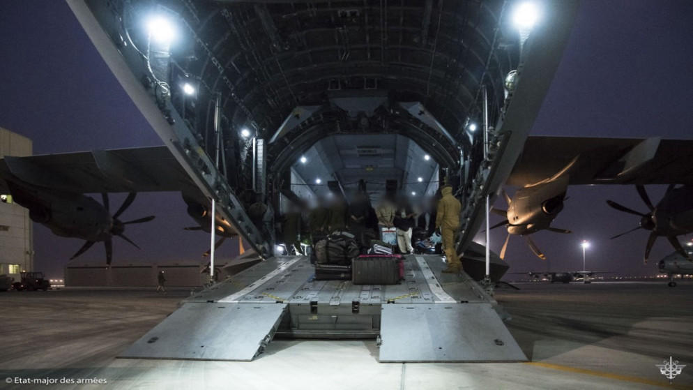 أشخاص على متن طائرة تابعة للقوات الجوية الفرنسية في قاعدة الظفرة الجوية، بالقرب من أبو ظبي بعد إجلائهم من كابل، 18 آب/أغسطس 2021 (أ ف ب)