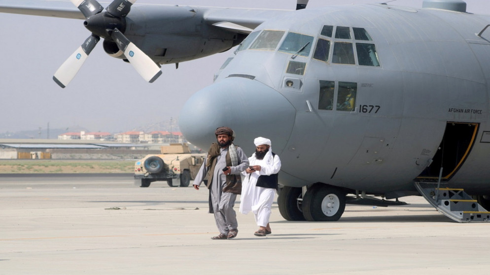 أعضاء من حركة طالبان، أمام طائرة عسكرية بعد يوم من انسحاب القوات الأميركية من مطار حامد كرزاي الدولي في كابل بأفغانستان، آب/ 31 أغسطس 2021. (رويترز)