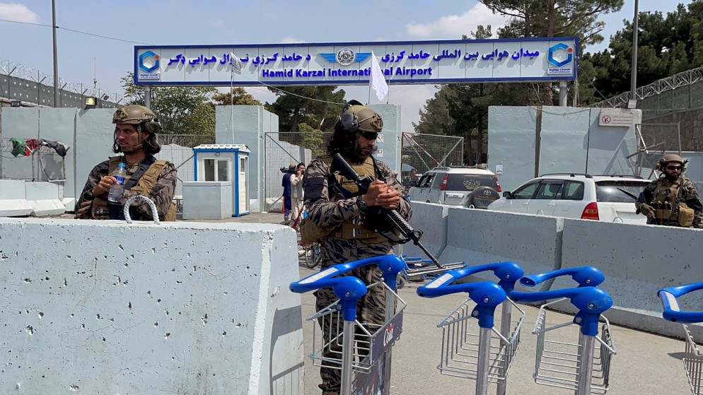 قوات طالبان تقف في حراسة عند بوابة مدخل مطار حامد كرزاي الدولي بعد يوم من انسحاب القوات الأميركية في كابل. (رويترز)
