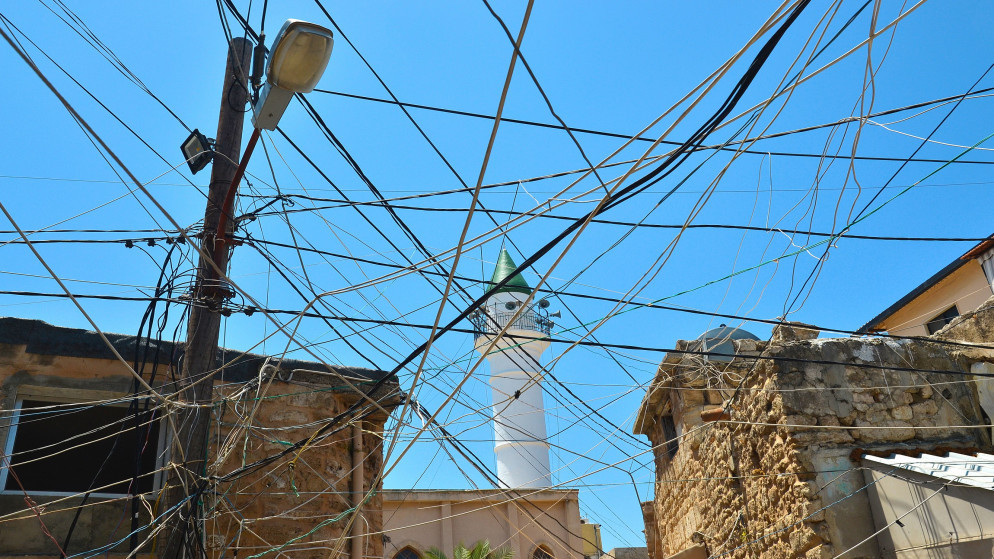 خطوط كهرباء بين المنازل في مدينة صور اللبنانية. (shutterstock)
