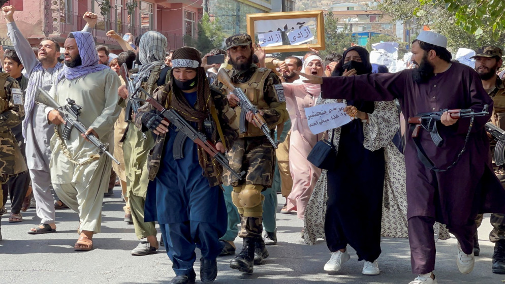 قوات طالبان تسير أمام الأفغان وهم يهتفون بشعارات خلال تظاهرة مناهضة لباكستان، بالقرب من السفارة الباكستانية في كابل، أفغانستان، 7 سبتمبر 2021. (رويترز)