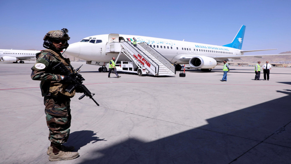 عنصر من حركة طالبان قرب طائرة في مطار كابل. (رويترز)