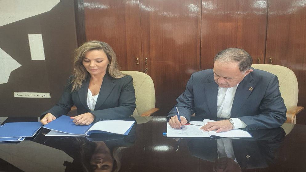 وزير المياه والري محمد النجار خلال توقيع اتفاقيتي مع نائبة مدير مكتب الإعمار الألماني لدى الأردن سوسن عاروري. (بترا)