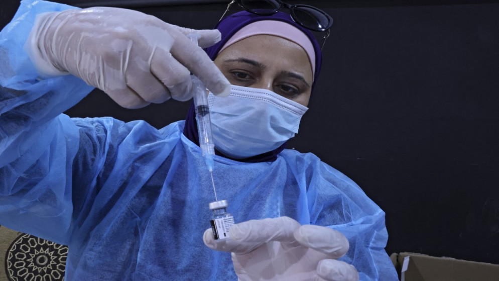 ممرضة تجهز حقنة من مطعوم فيروس كورونا في الأراضي الفلسطينية. (أ ف ب)