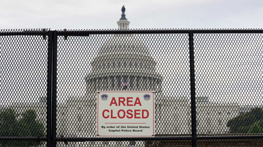 صورة أرشيفية لمبنى الكابيتول (الكونغرس) الأميركي خلف سياج أقيم في أعقاب أحداث 6 كانون الثاني/يناير (رويترز)