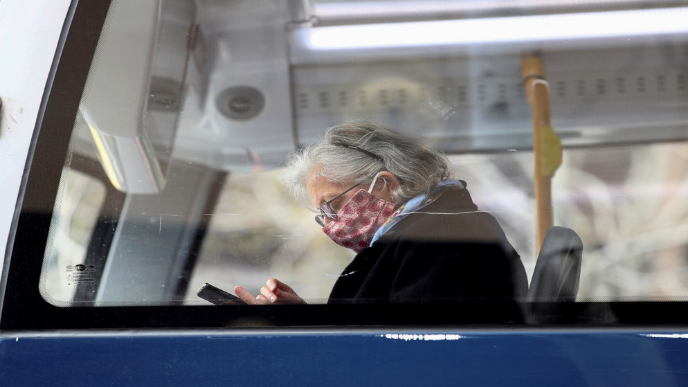 سيدة ترتدي كمامات للوقاية من فيروس كورونا تجلس في حافلة نقل عام في نيوزيلندا. 31/08/2020. (فيونا جودال/ رويترز)