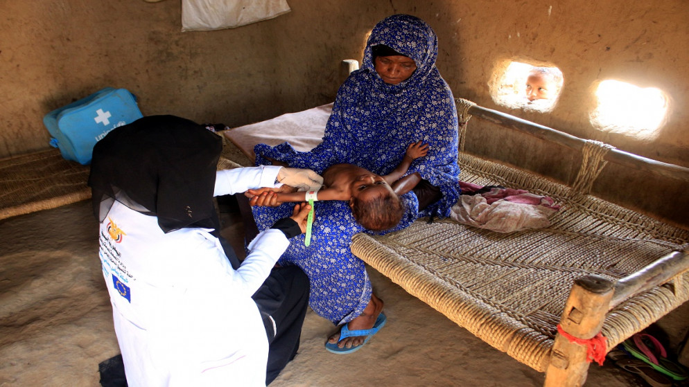 عاملة صحية متطوعة تقيس ذراع فتاة لتقييم حالتها التغذوية في عبس، اليمن، 31 آب/أغسطس 2021. (رويترز)