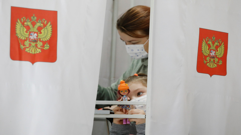 فتاة مع والدتها التي تقترع في مركز اقتراع في الانتخابات البرلمانية الروسية في ستافروبول في روسيا، 19 أيلول/ سبتمبر 2021. (رويترز)