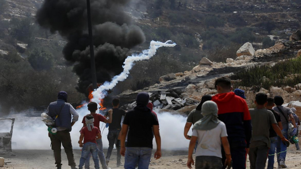 فلسطيني يرد قنبة مسيلة للدموع ألقاها جيش الاحتلال الإسرائيلي خلال مواجهات بالقرب من جبل صبيح في قرية بيتا جنوبي مدينة نابلس. 17/09/2021 (أيمن نوباني/ وفا)