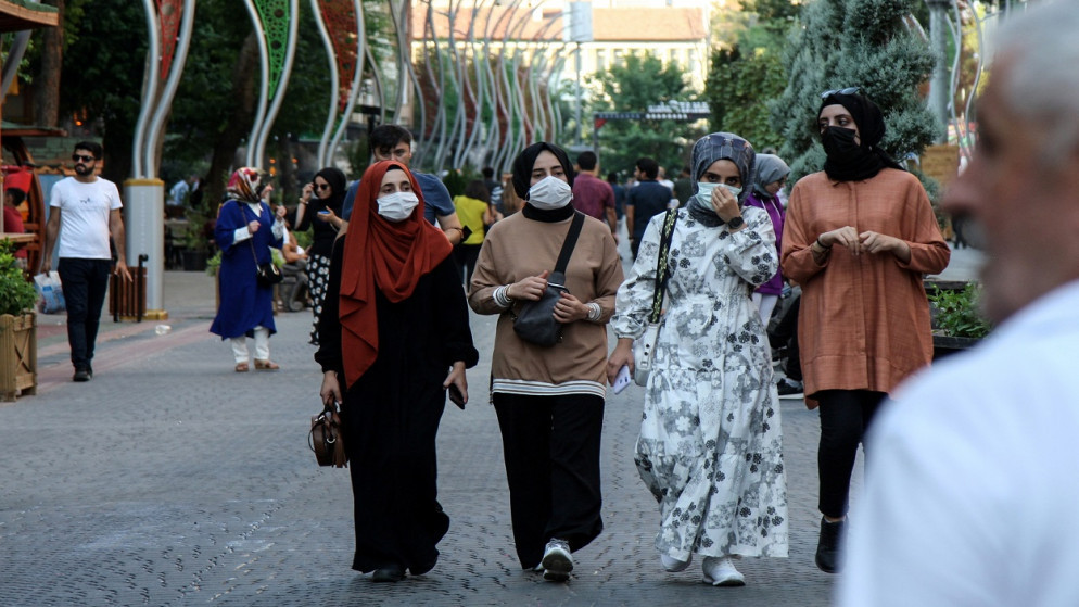 أشخاص يرتدون كمامات واقية يسيرون على طول أحد الشوارع وسط زيادة في حالات الإصابة بفيروس كورونا في ديار بكر، تركيا، 27 يوليو/تموز 2021. (رويترز)