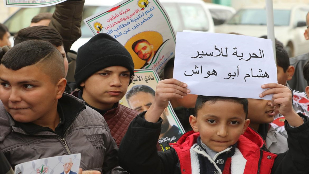 طفل فلسطيني يحمل لافتة تطالب بالإفراج عن الأسير هشام أبو هواش. (وفا)