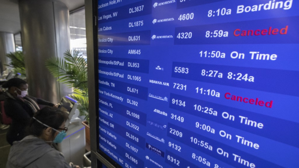 مسافرون يتحققون من معلومات الرحلة في مطار لوس أنجلوس الدولي. كاليفورنيا. 24 ديسمبر 2021.(أ ف ب)