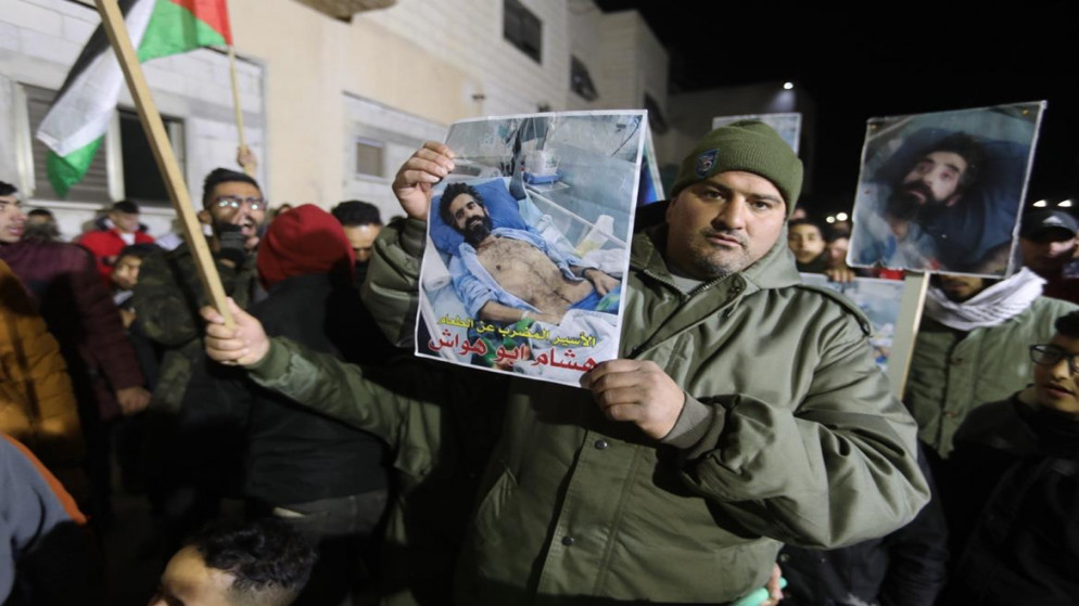 فلسطيني يرفع صورة الأسير الفلسطيني المضرب عن الطعام هشام أبو هواش خلال وقفة في بلدة دورا جنوب الخليل، 03/01/2022 (مشهور وحواح/وفا)