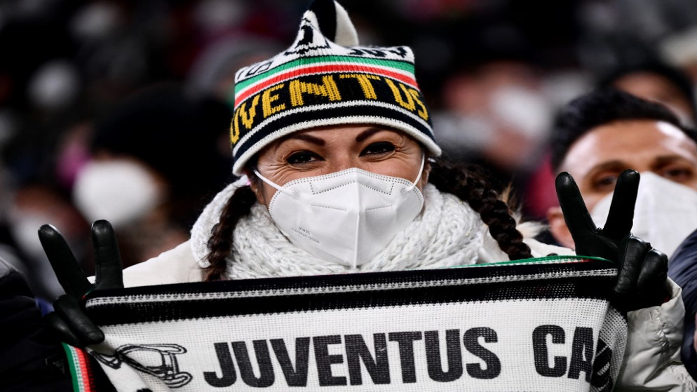 مشجعة إيطالية تحمل لفحة كتب عليها اسم نادي يوفنتوس الإيطالي. (أ ف ب)