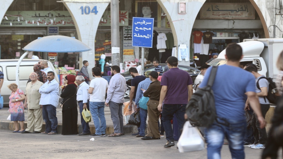 صورة أرشيفية لطابور بانتظار حافلة نقل عام في عمّان. (صلاح ملكاوي/ المملكة)