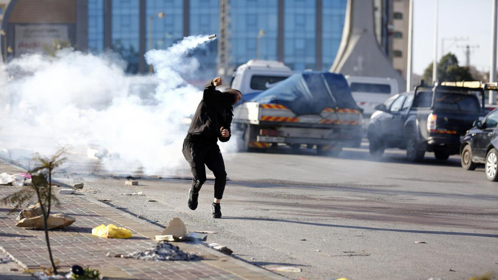 فلسطيني يرد قنبلة غاز إلى قوات الاحتلال الإسرائيلي خلال مواجهات على المدخل الشمالي لمدينة البيرة، رام الله، الضفة الغربية المحتلة، 11/01/2022 (وفا)