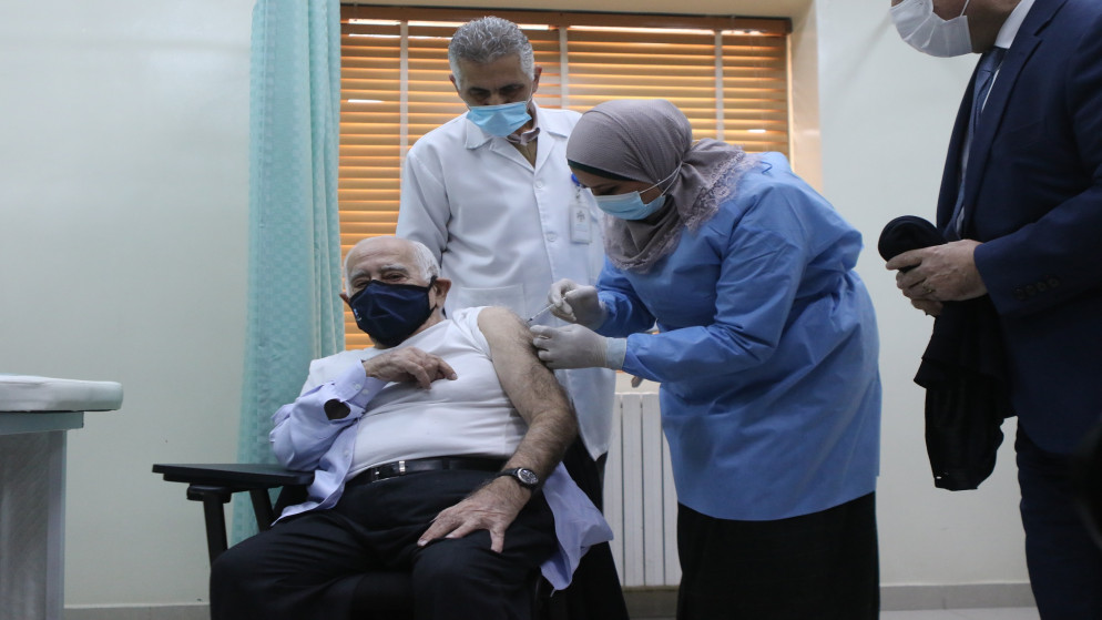 العين السابق الطبيب داود حنانيا خلال تلقيه اللقاح المضاد لفيروس كورونا، في مركز صحي الجبيهة. (صلاح ملكاوي/ المملكة)