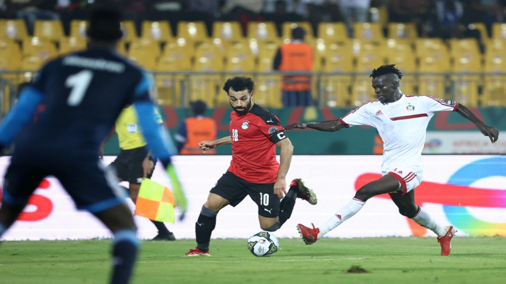 النجم المصري محمد صلاح وهو يستحوذ على الكرة ضد مدافع منتخب السودان في كأس الأمم الإفريقية. (أ ف ب)