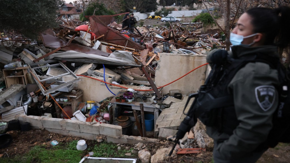 مجندة إسرائيلية تقف على أنقاض منزل فلسطيني هدمته قوات الاحتلال الإسرائيلية في حي الشيخ جراح في القدس المحتلة. 19/01/2022. (أ ف ب)