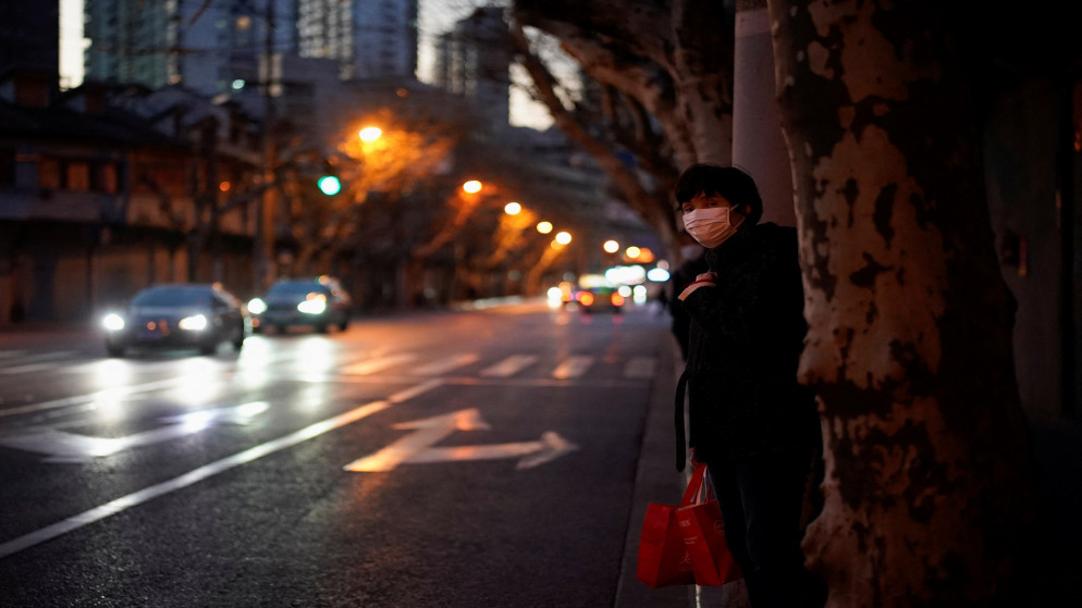 امرأة ترتدي كمامات للوقاية من فيروس كورونا تنتظر حافلة في شارع بشنغهاي الصينية. 20/01/2022. (علي سونغ/ رويترز)