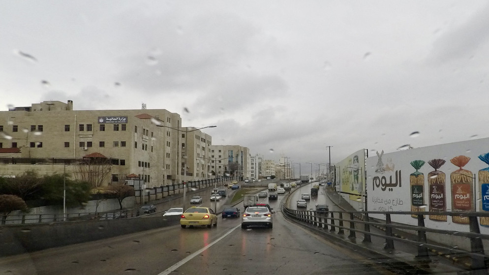 حركة مركبات في شارع رئيسي في منطقة الشميساني في عمّان خلال يوم ماطر. (صلاح ملكاوي / المملكة)