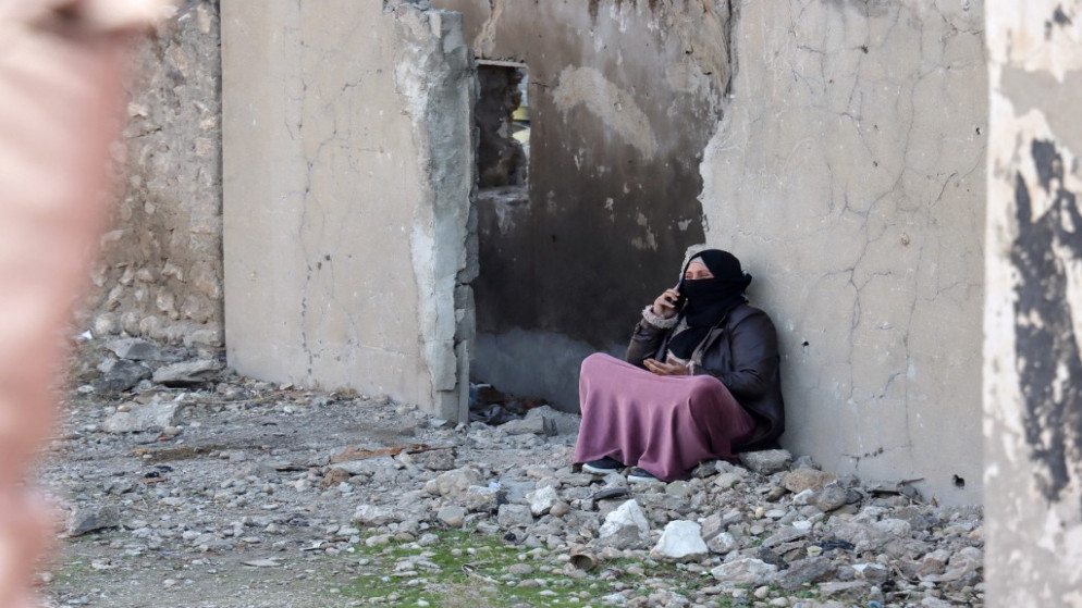 امرأة تتحدث عبر الهاتف بينما يفر السوريون من منازلهم في حي الغويران في مدينة الحسكة الشمالية. 22/01/2022. (أ ف ب)