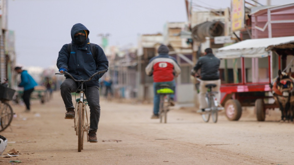 لاجئ سوري يقود دراجة هوائية في شارع رئيسي بمخيم الزعتري بمحافظة المفرق شمالي الأردن. (محمد حواري/الأمم المتحدة)