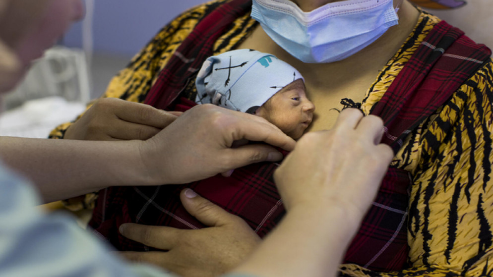 متين على جسد أمه شنين على طريقة رعاية الأم الكنغر في مستشفى في السليمانية العراقية، 11 نيسان/أبريل 2022. (أ ف ب)