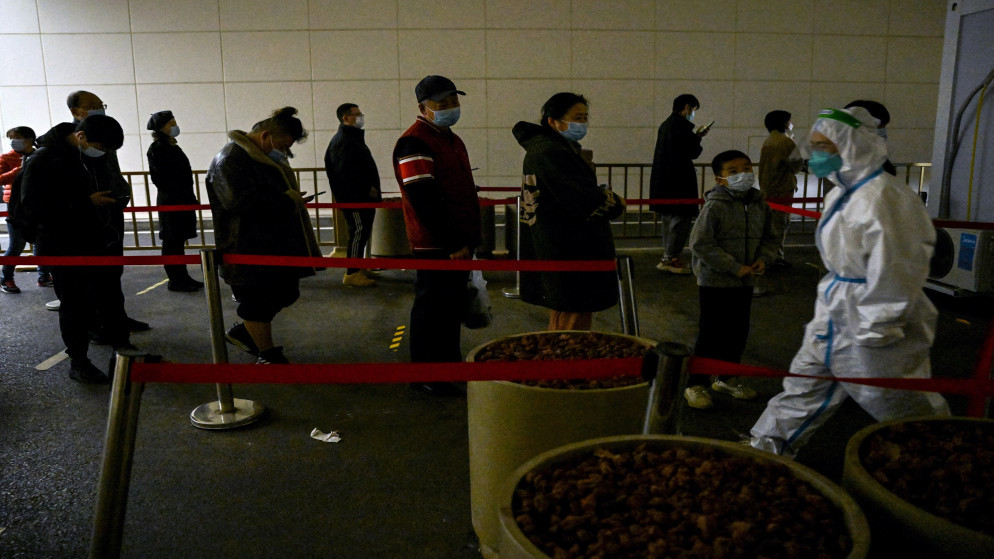 أشخاص يصطفون في طابور لاختبار فيروس كورونا في محطة جمع المسحات في بكين. 20 نوفمبر 2022. (أ ف ب)