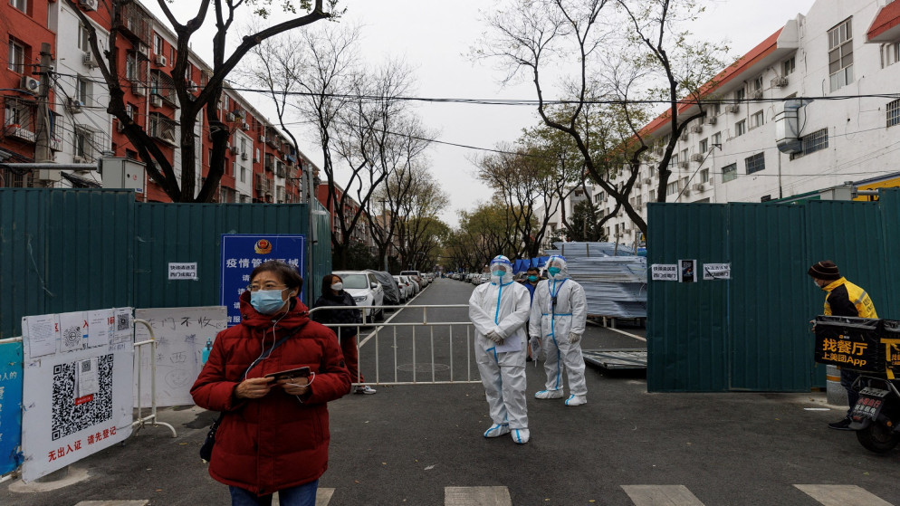 عمال الوقاية من الأوبئة يرتدون بدلات واقية يقفون لحراسة مجمع سكني مع استمرار تفشي مرض فيروس كورونا في بكين، الصين 28 نوفمبر / تشرين الثاني 2022. (رويترز)