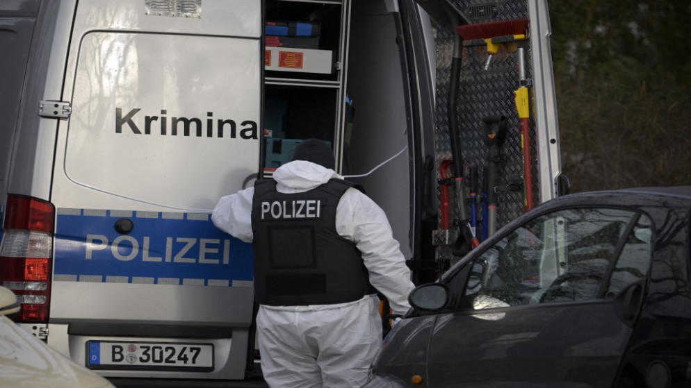 شرطي خلف مركبة للطب الشرعي في برلين. (أ ف ب)