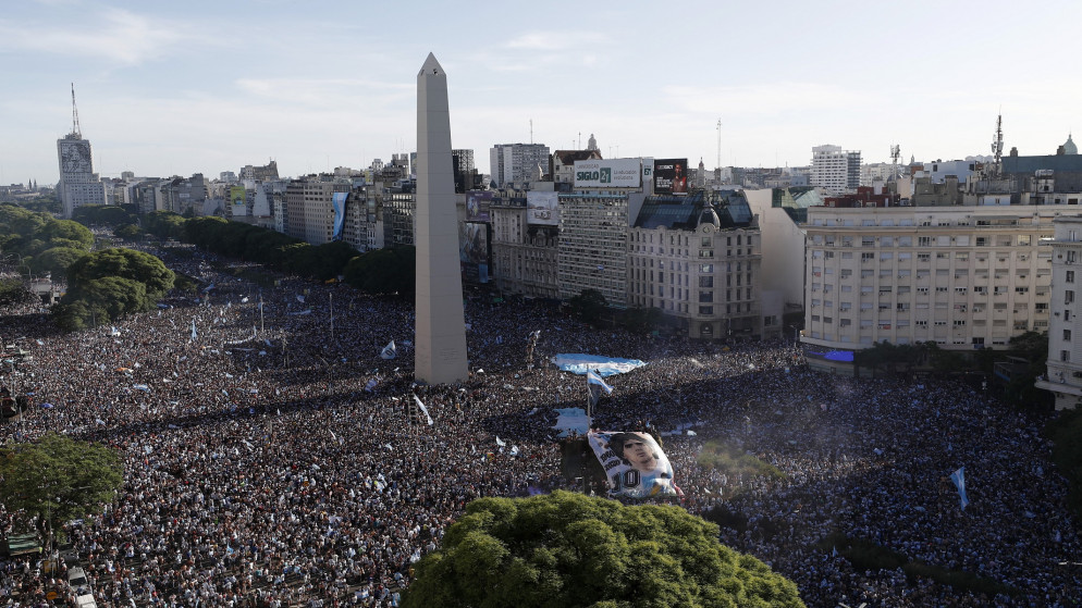 مشجعون أرجنتينيون في ساحة أوبيليسكو في بوينس أيرس يحتفلون بعد الفوز بكأس العالم. (رويترز)