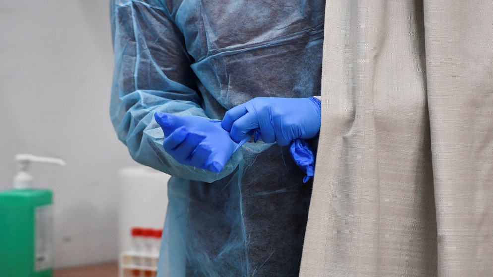عامل في القطاع الصحي في إيطاليا يرتدي القفازات للوقاية من فيروس كورونا. (رويترز)