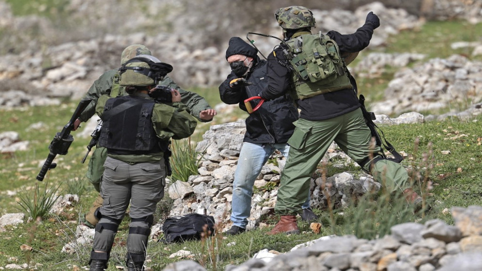 قوات الاحتلال الإسرائيلية تمنع نشطاء سلام من مساعدة فلسطينيين يزرعون أشجار زيتون في أرضهم في قرية بورين في الضفة الغربية المحتلة. 04/02/2022. (جعفر اشتية /أ ف ب)