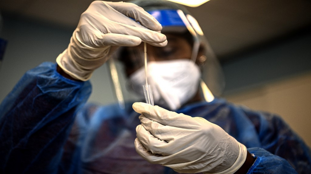 شخص يحمل فحص PCR  للكشف عن فيروس كورونا. (أ ف ب)
