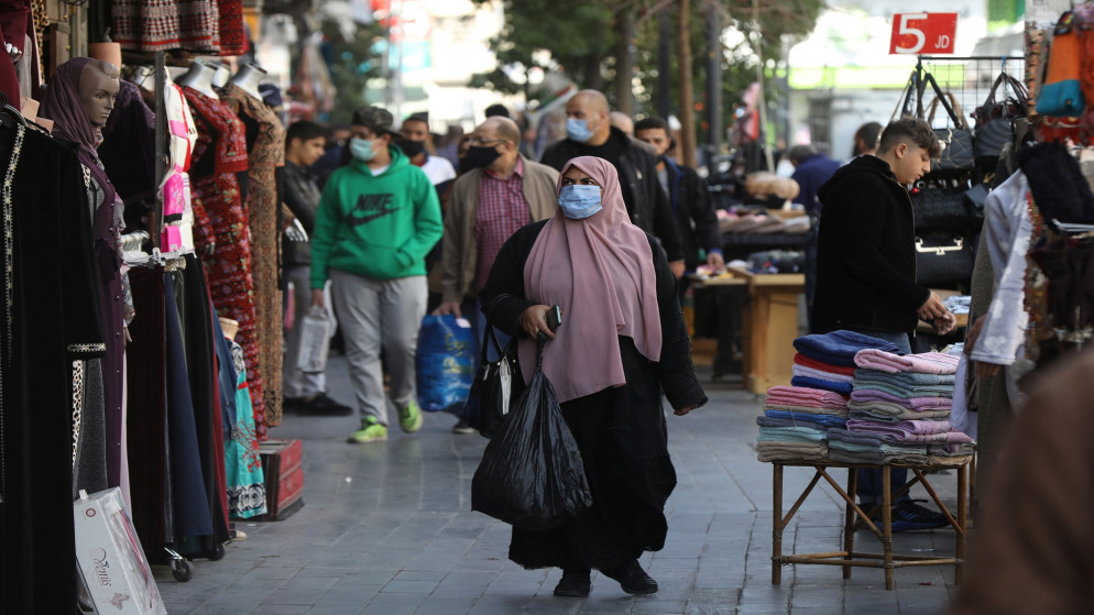 امرأة ترتدي كمامة في شارع في وسط البلد في عمّان. (رويترز)