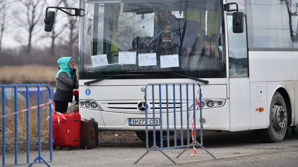 امرأة تتحدث مع سائق حافلة بعد فرارها من أوكرانيا إلى رومانيا بعد الهجوم الروسي على مدن أوكرانية. 06/03/2022. (كلودا كيلكوين/ رويترز)