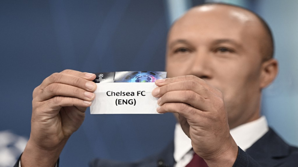 اللاعب الفرنسي السابق سيلفستر يحمل ورقة عليها اسم نادي تشيلسي أثناء قرعة دوري أبطال أوروبا في نيون السويسرية. (أ ف ب)