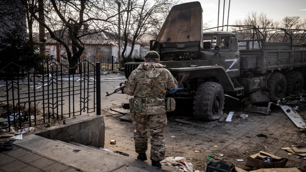 عنصر من القوات الأوكرانية قرب شاحنة للقوات الروسية قرب منطقة تروستنتس الأوكرانية. (أ ف ب)