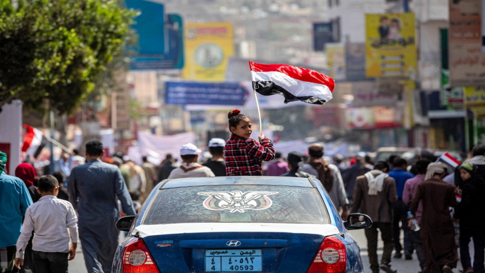 يمنية تحمل العلم اليمني خلال مسيرة في مدينة تعز. 12 فبراير 2022. (أ ف ب)