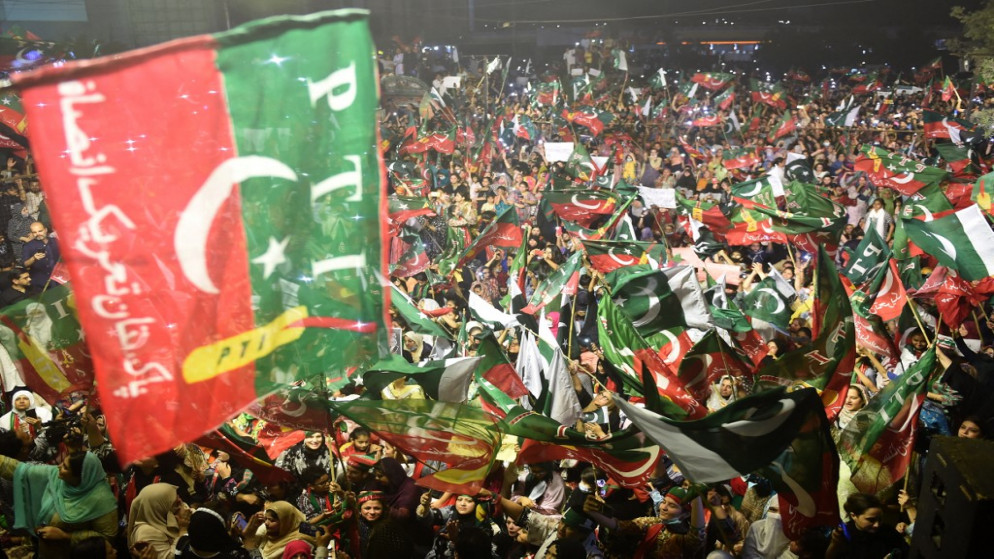 أنصار أحد الأحزاب في باكستان يلوحون بأعلام أثناء مشاركتهم في مسيرة، 10 أبريل 2022. (أ ف ب)