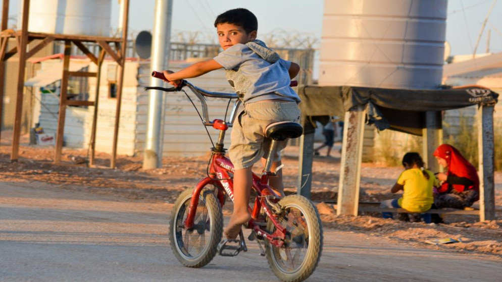 طفل سوري يسير على دراجة هوائية في أحد شوارع مخيم الزعتري بمحافظة المفرق. (مفوضية الأمم المتحدة للاجئين)