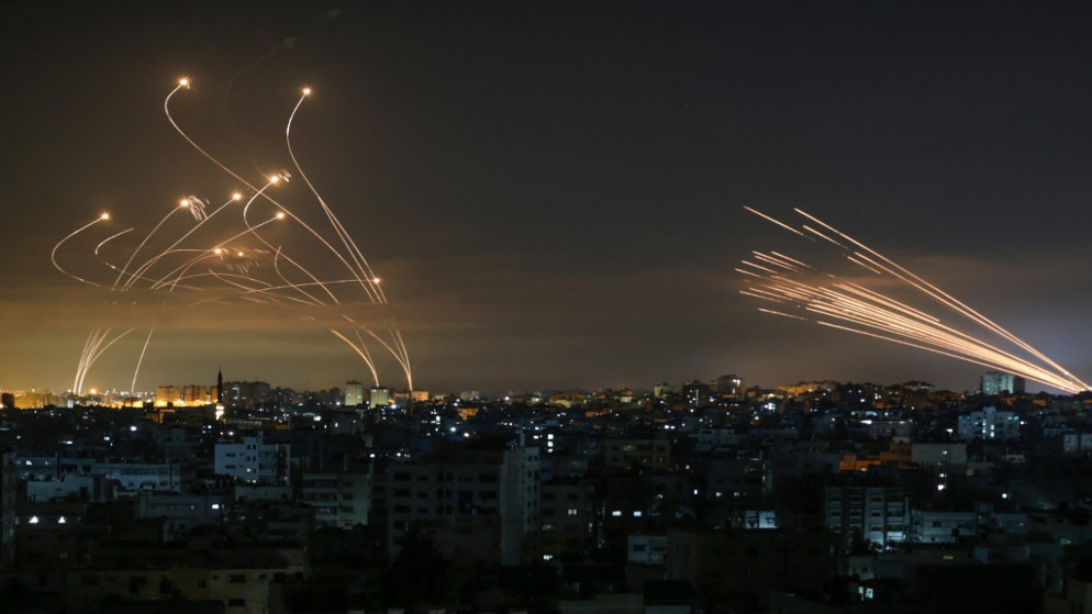 صورة أرشيفية لنظام القبة الحديدية (يسار) يحاول اعتراض صواريخ المقاومة الفلسطينية (يمين) في سماء قطاع غزة، 14 أيار/ مايو 2021. (أنس البابا/ أ ف ب)