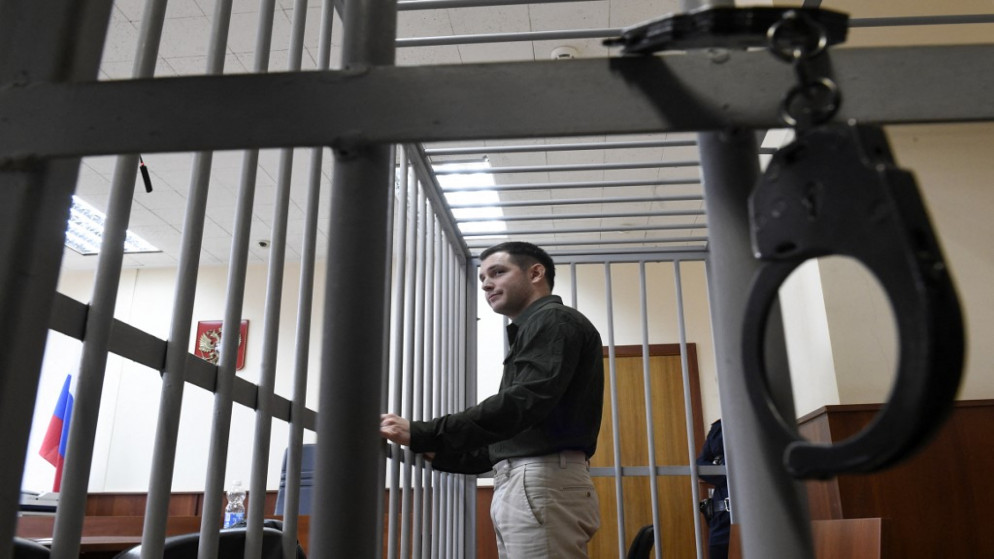عنصر المارينز الأميركي السابق تريفور ريد داخل قفص حديد خلال وقوفه أمام محكمة في روسيا. (أ ف ب)