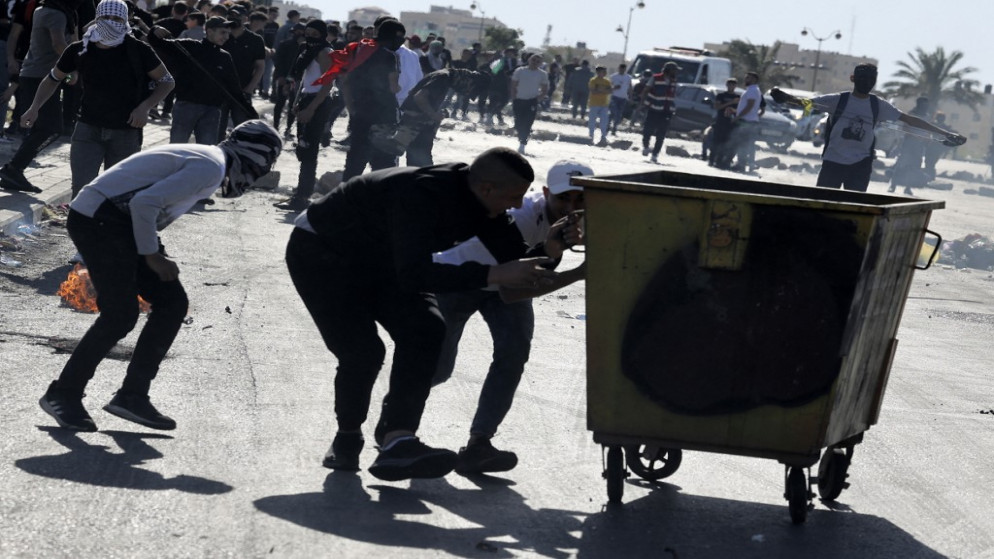 متظاهرون فلسطينيون خلال مواجهات مع قوات الاحتلال الإسرائيلي عقب مسيرة لإحياء الذكرى 74 لـ "النكبة"في الضفة الغربية المحتلة ، 15 مايو ، 2022.(أ ف ب)